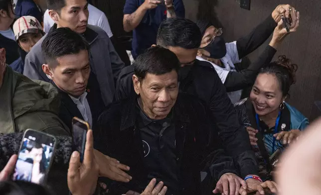 Former President of the Philippines Rodrigo Duterte arrives inside the Southorn Stadium during a thanksgiving gathering organized by Hong Kong-based Filipino workers for the former populist president in Hong Kong on Sunday, March 9, 2025. (AP Photo/Vernon Yuen)
