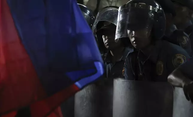 Police guard the gate as supporters of former Philippine President Rodrigo Duterte gather outside the Villamor Air Base in Manila, Philippines, Tuesday, March 11, 2025. (AP Photo/Basilio Sepe)