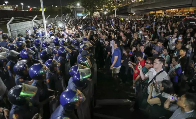Supporters of former President Rodrigo Duterte rush to the fence of the Villamor Air Base in Manila, Philippines, Wednesday March 11, 2025, upon learning that the plane taking the ex-president to The Hague has left the airport. (AP Photo/Gerard Carreon)