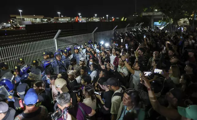 Supporters of former President Rodrigo Duterte rush to the fence of the Villamor Air Base in Manila, Philippines, Wednesday March 11, 2025, upon learning that the plane taking the ex-president to The Hague has left the airport.(AP Photo/Gerard Carreon)