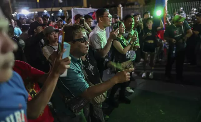 Supporters of former President Rodrigo Duterte rush to the fence of the Villamor Air Base in Manila, Philippines, Wednesday March 11, 2025, upon learning that the plane taking the ex-president to The Hague has left the airport.(AP Photo/Gerard Carreon)