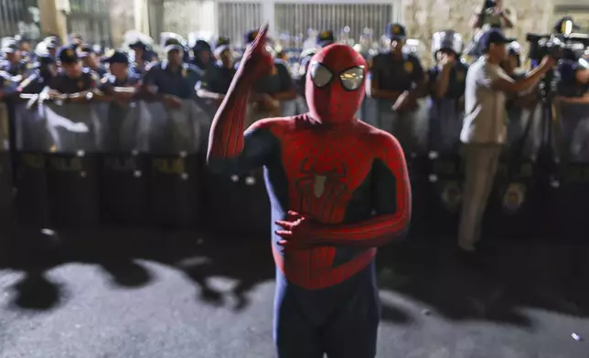 A supporter of former President Duterte dressed in a spiderman costume shout slogans at Villamor Air Base in Manila, Philippines, Wednesday March 11, 2025. (AP Photo/Gerard Carreon)