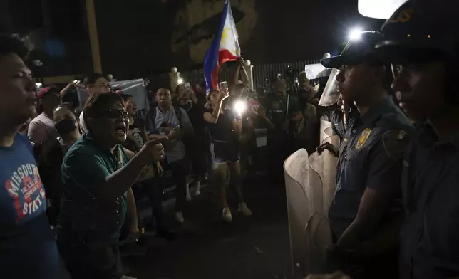 Supporters of former Philippine President Rodrigo Duterte confront police as they gather outside the Villamor Air Base in Manila, Philippines, Tuesday, March 11, 2025. (AP Photo/Basilio Sepe)