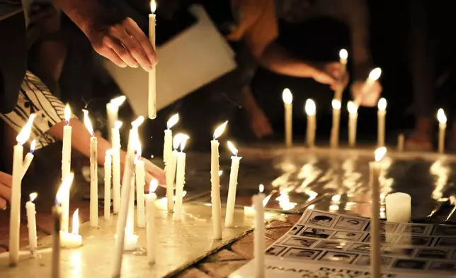 Relatives of victims of drug war and extrajudicial killings and activists light candles during a protest against former Philippine President Rodrigo Duterte following his arrest in Quezon City, Philippines, Tuesday, March 11, 2025. (AP Photo/Basilio Sepe)