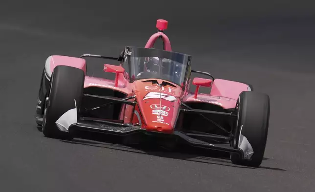 FILE - Katherine Legge, of England, drives through the first turn during qualifications for the Indianapolis 500 auto race at Indianapolis Motor Speedway in Indianapolis, Saturday, May 18, 2024. (AP Photo/Michael Conroy, File)