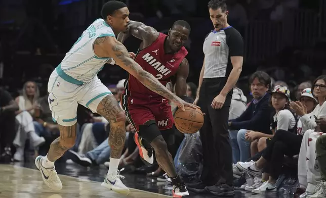 Charlotte Hornets guard DaQuan Jeffries (3) and Miami Heat guard Terry Rozier (2) go after the ball during the first half of an NBA basketball game, Monday, March 10, 2025, in Miami. (AP Photo/Marta Lavandier)