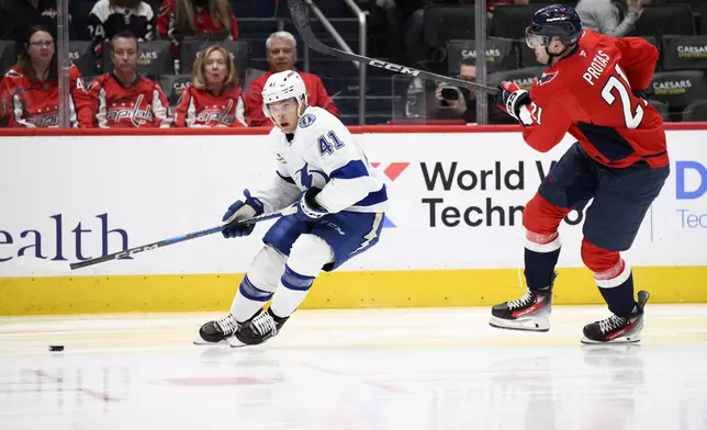 Tampa Bay Lightning right wing Mitchell Chaffee (41) chases the puck past Washington Capitals center Aliaksei Protas (21) during the second period of an NHL hockey game, Saturday, March 1, 2025, in Washington. (AP Photo/Nick Wass)