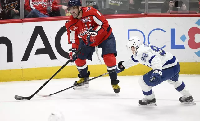 Washington Capitals left wing Alex Ovechkin (8) looks to pass against Tampa Bay Lightning defenseman J.J. Moser (90) during the third period of an NHL hockey game, Saturday, March 1, 2025, in Washington. (AP Photo/Nick Wass)