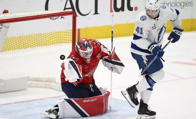 Washington Capitals goaltender Logan Thompson, left, and Tampa Bay Lightning right wing Mitchell Chaffee (41) watch the puck shot by center Gage Goncalves (93) get by for a goal during the third period of an NHL hockey game, Saturday, March 1, 2025, in Washington. (AP Photo/Nick Wass)