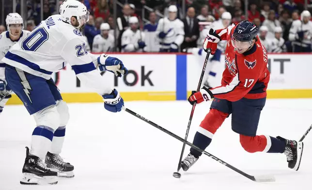 Washington Capitals center Dylan Strome (17) shoots against Tampa Bay Lightning left wing Nick Paul (20) during the first period of an NHL hockey game, Saturday, March 1, 2025, in Washington. (AP Photo/Nick Wass)