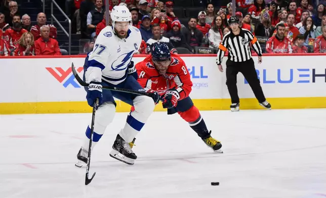 Washington Capitals left wing Alex Ovechkin (8) hooks Tampa Bay Lightning defenseman Victor Hedman (77) during the first period of an NHL hockey game, Saturday, March 1, 2025, in Washington. (AP Photo/Nick Wass)