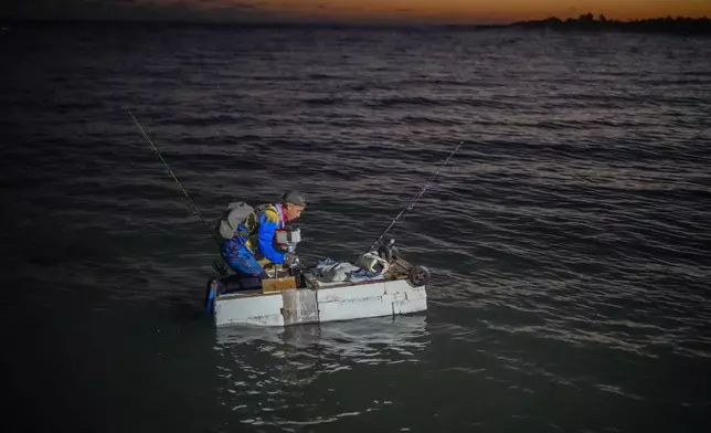 A man on a makeshift "corcho" raft prepares to fish at dawn in Cojimar, east of Havana, Cuba, Wednesday, March 12, 2025. (AP Photo/Ramon Espinosa)