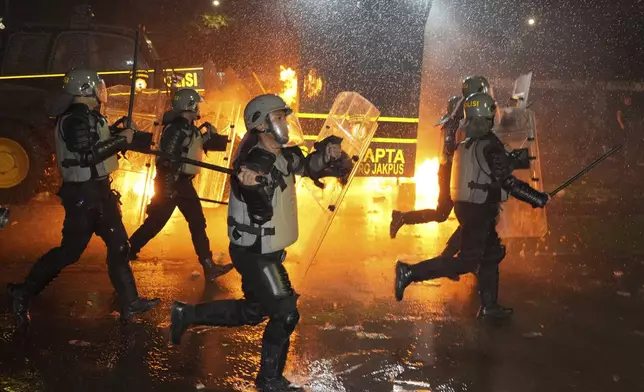 Police officers chase protesters during a rally against the passing of a controversial revision of a military law that will allow military officers to serve in more government posts without resigning from the armed forces, outside the parliament in Jakarta, Indonesia, Thursday, March 27, 2025. (AP Photo/Achmad Ibrahim)