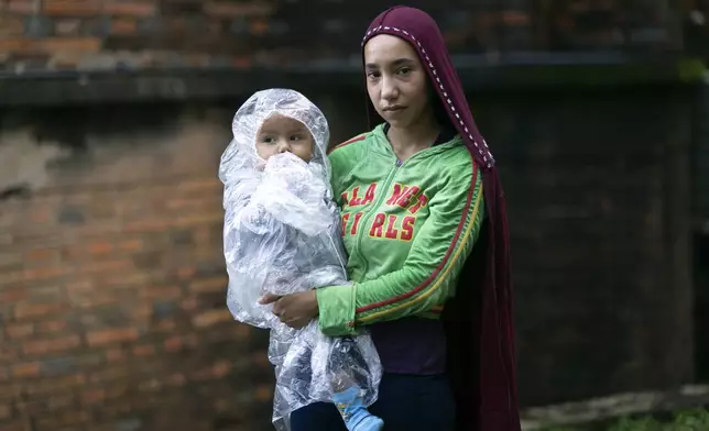 Young farmer Beatriz Sanchez, 17, from the Ypehu settlement, poses for a portrait with her son Martin before participating in the annual farmers' march for agrarian reform, better public health services and education, and economic help for their sector in Asuncion, Paraguay, Thursday, March 27, 2025. (AP Photo/Jorge Saenz)