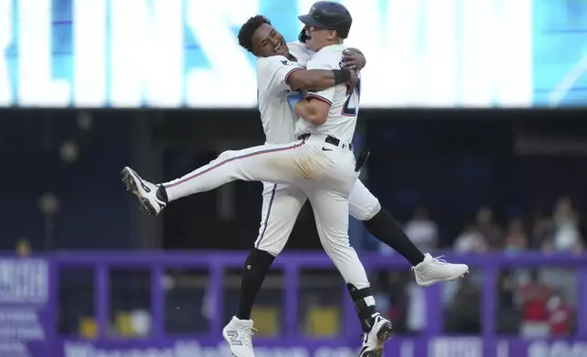 Miami Marlins' Dane Myers, left, and Kyle Stowers, right, celebrate after Stowers hit a walk-off single to score Javier Sanoja during the ninth inning of an opening-day baseball game against the Pittsburgh Pirates, Thursday, March 27, 2025, in Miami. (AP Photo/Lynne Sladky)