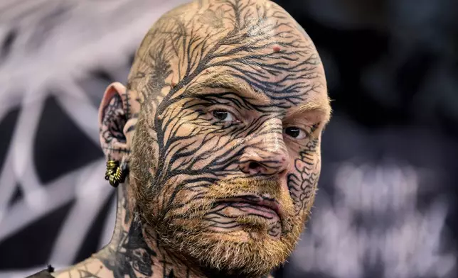 A man looks on during the Gods of Ink Tattoo Convention with 400 international tattoo artists in Frankfurt, Germany, Friday, March 28, 2025. (AP Photo/Michael Probst)