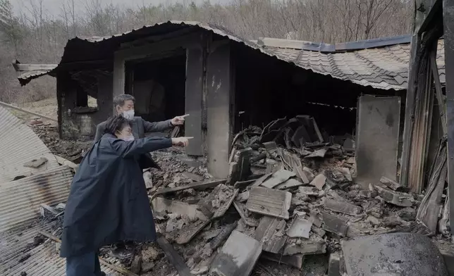 Lee Hae-soo and his wife Byung Jung-ee, left, watch their burnt-out house at a damaged village due to wildfires in Andog, South Korea, Friday, March 28, 2025. (AP Photo/Ahn Young-joon)