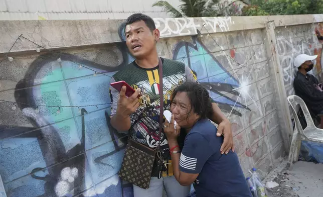 A woman weeps as rescue work is underway at the site of an under-construction high-rise building that collapsed on Friday after an earthquake in Bangkok, Thailand, Saturday, March 29, 2025. (AP Photo/Sakchai Lalit)