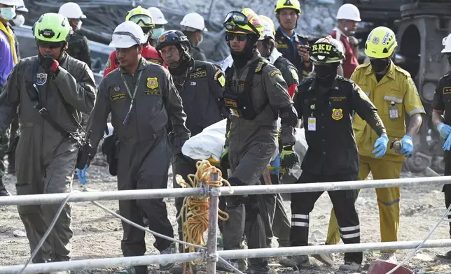 Thai rescue workers carry a body from a high-rise building under construction that collapsed after a strong earthquake, in Bangkok, Thailand, Saturday, March 29, 2025. (AP Photo/Thiti Wannamontha)