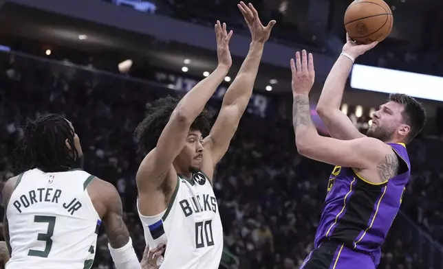 Los Angeles Lakers' Luka Doncic shoots past Milwaukee Bucks' Kevin Porter Jr. and Jericho Sims during the first half of an NBA basketball game Thursday, Mar. 13, 2025, in Milwaukee. (AP Photo/Morry Gash)