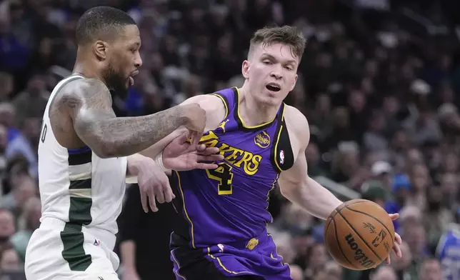 Los Angeles Lakers' Dalton Knecht tries to get past Milwaukee Bucks' Damian Lillard during the first half of an NBA basketball game Thursday, Mar. 13, 2025, in Milwaukee. (AP Photo/Morry Gash)