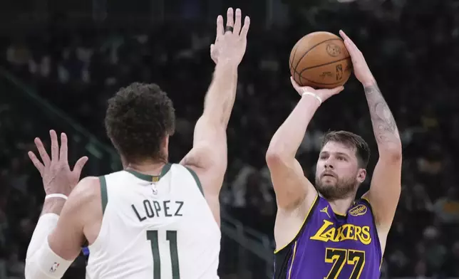 Los Angeles Lakers' Luka Doncic shoots past Milwaukee Bucks' Brook Lopez during the first half of an NBA basketball game Thursday, Mar. 13, 2025, in Milwaukee. (AP Photo/Morry Gash)