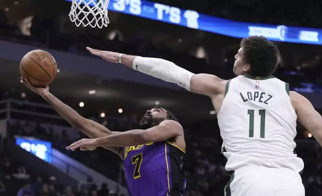 Los Angeles Lakers' Gabe Vincent shoots past Milwaukee Bucks' Brook Lopez during the first half of an NBA basketball game Thursday, Mar. 13, 2025, in Milwaukee. (AP Photo/Morry Gash)