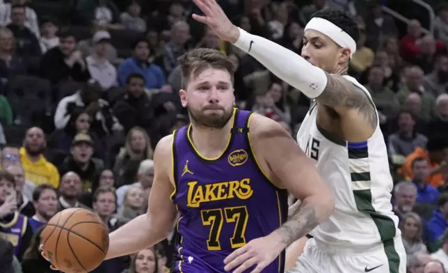 Los Angeles Lakers' Luka Doncic tries to get past Milwaukee Bucks' Kyle Kuzma during the first half of an NBA basketball game Thursday, March 13, 2025, in Milwaukee. (AP Photo/Morry Gash)