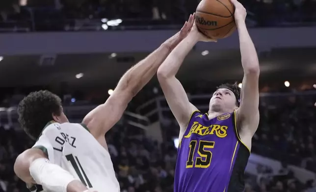 Milwaukee Bucks' Brook Lopez fouls Los Angeles Lakers' Austin Reaves during the first half of an NBA basketball game Thursday, Mar. 13, 2025, in Milwaukee. (AP Photo/Morry Gash)