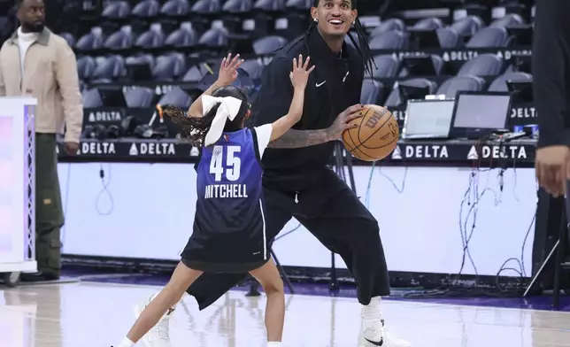 Utah Jazz guard Jordan Clarkson warms up with his daughter before an NBA basketball game against the Cleveland Cavaliers, Sunday, March 23, 2025, in Salt Lake City. (AP Photo/Rob Gray)