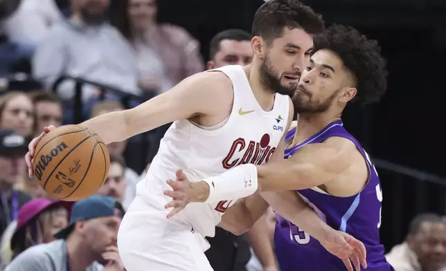 Cleveland Cavaliers guard Ty Jerome, left, dribbles as Utah Jazz guard Johnny Juzang, right, defends during the first half of an NBA basketball game, Sunday, March 23, 2025, in Salt Lake City. (AP Photo/Rob Gray)