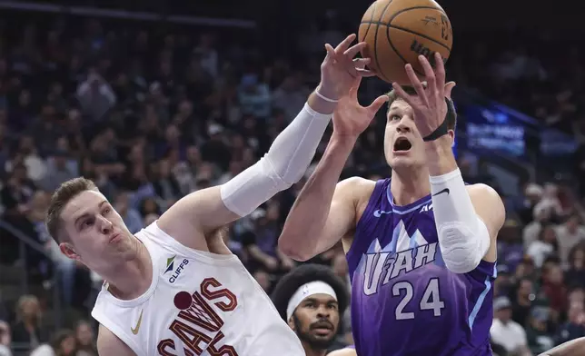Cleveland Cavaliers guard Sam Merrill (5) and Utah Jazz center Walker Kessler (24) battle for a rebound during the first half of an NBA basketball game, Sunday, March 23, 2025, in Salt Lake City. (AP Photo/Rob Gray)