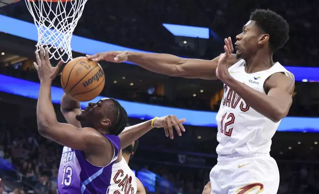 Cleveland Cavaliers forward De'Andre Hunter (12) blocks a shot by Cleveland Cavaliers center Tristan Thompson (13) during the first half of an NBA basketball game, Sunday, March 23, 2025, in Salt Lake City. (AP Photo/Rob Gray)