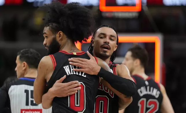 Chicago Bulls guard Tre Jones (30), right, and guard Coby White (0) celebrate their team's win over the Brooklyn Nets in an NBA basketball game Thursday, March 13, 2025, in Chicago. (AP Photo/Erin Hooley)