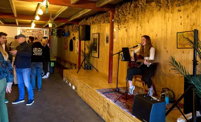 An artist performs inside the Enid Street Tavern on the Bermondsey Beer Mile in south London, Saturday March 8, 2025. (AP Photo/Tony Hicks)