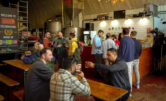 People have a drink in the Southwark Brewing Co., one of the bars on the Bermondsey Beer Mile in south London, Saturday March 8, 2025. (AP Photo/Tony Hicks)