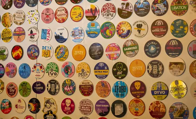 A selection of beer mats are attached to the wall inside the Enid Street Tavern on the Bermondsey Beer Mile in south London, Saturday March 8, 2025. (AP Photo/Tony Hicks)