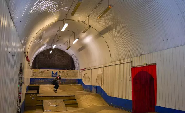 A young skateboarder makes a jump inside Hop Kingdom, a bar on the Bermondsey Beer Mile in south London, Saturday March 8, 2025. (AP Photo/Tony Hicks)