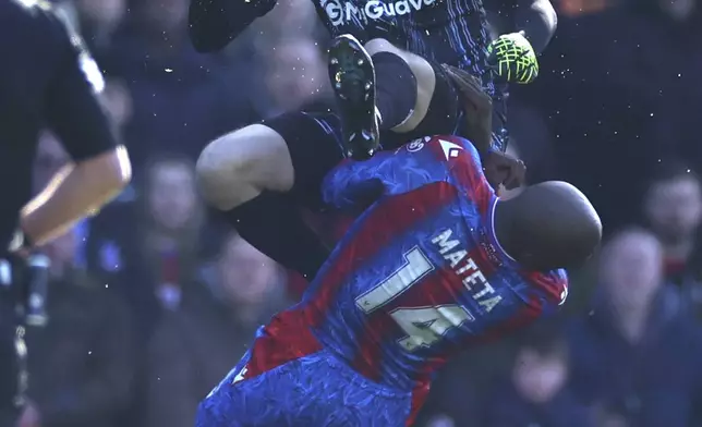 Millwall's goalkeeper Liam Roberts, atop, collides with Crystal Palace's Jean-Philippe Mateta during the English FA Cup soccer match between Crystal Palace and Millwall at Selhurst Park, London, England, Saturday, March 1, 2025. (AP Photo/Ian Walton)