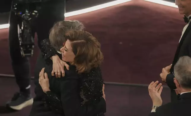 Fernanda Torres, right, embraces Walter Salles after he wins the award for "I'm Still Here" from Brazil, for best international feature film during the Oscars on Sunday, March 2, 2025, at the Dolby Theatre in Los Angeles. (AP Photo/Chris Pizzello)
