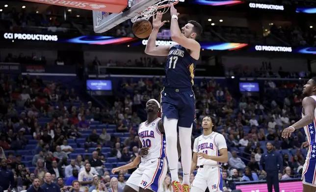 New Orleans Pelicans center Karlo Matkovic (17) dunks against Philadelphia 76ers center Adem Bona (30) during the first half of an NBA basketball game in New Orleans, Monday, March 24, 2025. (AP Photo/Matthew Hinton)