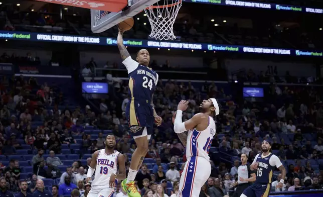 New Orleans Pelicans guard Jordan Hawkins (24) shoots against Philadelphia 76ers forward Chuma Okeke (18) during the first half of an NBA basketball game in New Orleans, Monday, March 24, 2025. (AP Photo/Matthew Hinton)