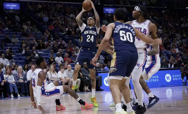New Orleans Pelicans guard Jordan Hawkins (24) shoots against Philadelphia 76ers forward Justin Edwards (19) during the first half of an NBA basketball game in New Orleans, Monday, March 24, 2025. (AP Photo/Matthew Hinton)