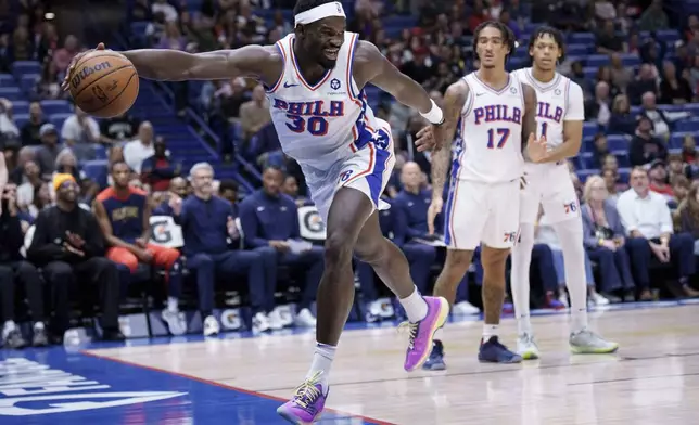 Philadelphia 76ers center Adem Bona (30) tries to keep the ball inbounds during the first half of an NBA basketball game against the New Orleans Pelicans in New Orleans, Monday, March 24, 2025. (AP Photo/Matthew Hinton)