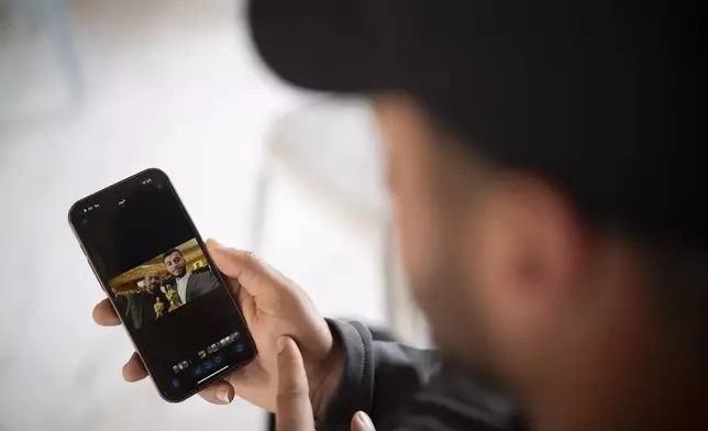 Salem Adra, shows a photo on his mobile phone in the West Bank village of Tuwani, Monday, March 3, 2025, depicting his brother, Palestinian activist Basel Adra, right, and Hamdan Ballal after they have been awarded Best Documentary Feature at the Oscars for "No Other Land". (AP Photo/Leo Correa)