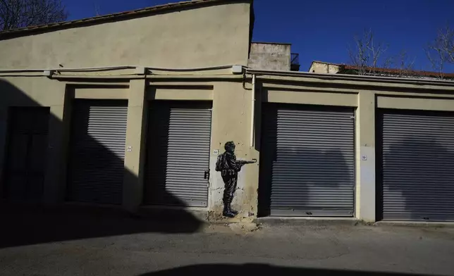 A painting showing a soldier is seen across the U.N buffer zone in divided capital Nicosia, Cyprus, Tuesday, March 18, 2025. (AP Photo/Petros Karadjias)