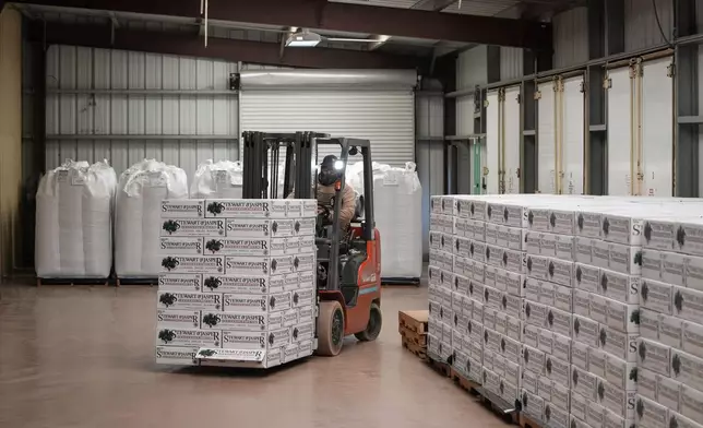 A worker moves 50-pound boxes of almonds at Stewart and Jasper Orchards, Friday, March 7, 2025, in Newman, Calif. (AP Photo/Godofredo A. Vásquez)