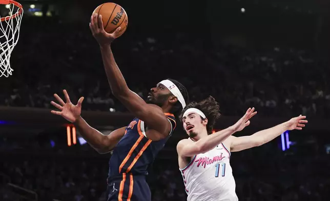 New York Knicks forward Precious Achiuwa, left, drives to the basket past Miami Heat guard Jaime Jaquez Jr. (11) during the first half of an NBA basketball game, Monday, March 17, 2025, in New York. (AP Photo/Heather Khalifa)
