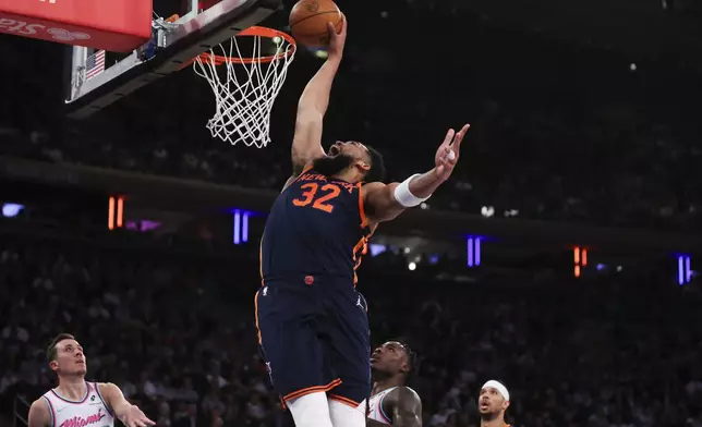 New York Knicks center Karl-Anthony Towns (32) dunks during the first half of an NBA basketball game against the Miami Heat, Monday, March 17, 2025, in New York. (AP Photo/Heather Khalifa)