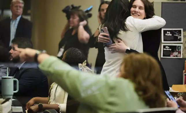 NASA employees react on Tuesday, March 18, 2025, at Johnson Space Center in Houston after watching astronauts splash down off the coast of Florida. (AP Photo/Ashley Landis)
